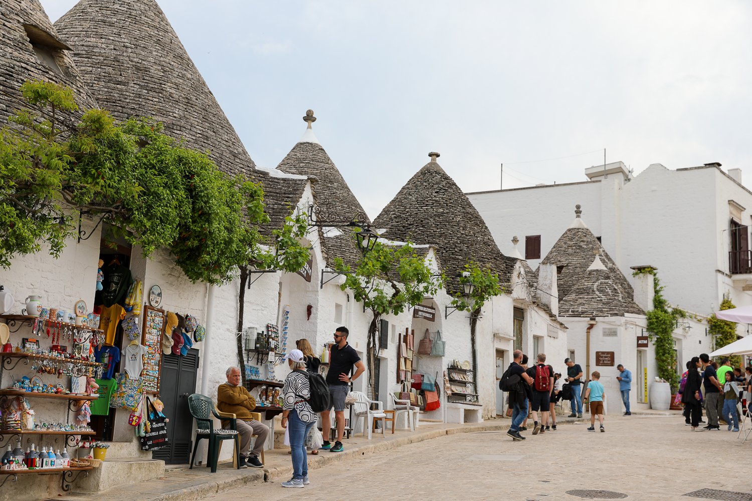 Tourists passing by souvenir shops in Alberobello, Puglia's trulli town