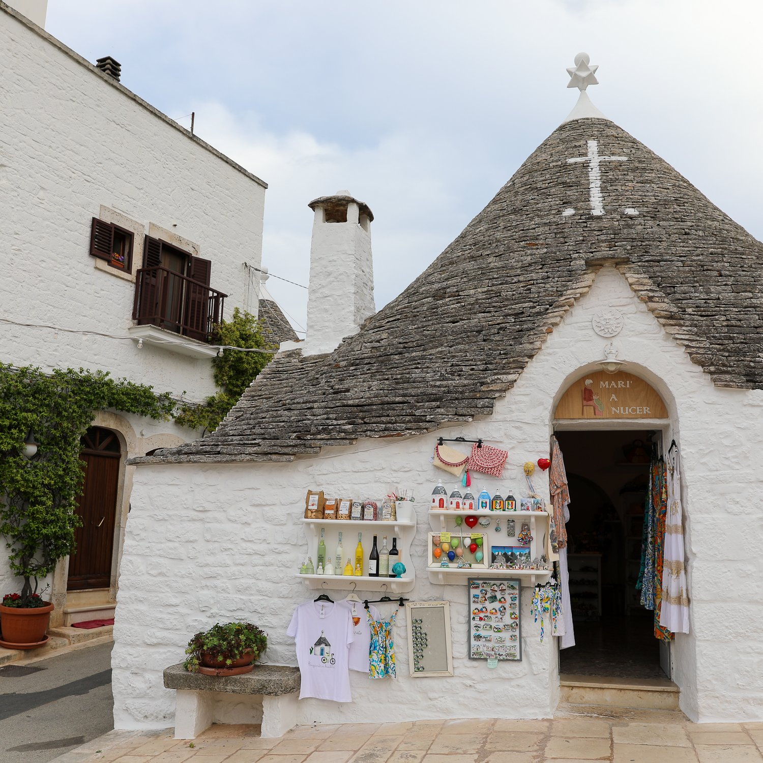 Souvenir shop with displays on its facade. One of the best things to do in Alberobello is finding a souvenir to remember your trip.