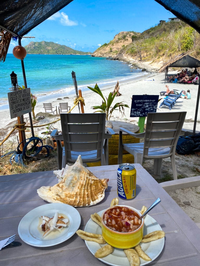 Snacks and beer under the hut's shade at Almond Bay