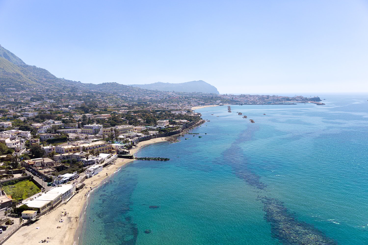 View of Ischia's coastal town and its clear, blue ocean waters