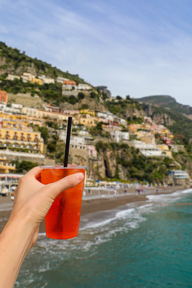 Holding up a cup of Aperol Spritz, a refreshing cocktail to try in Amalfi Coast