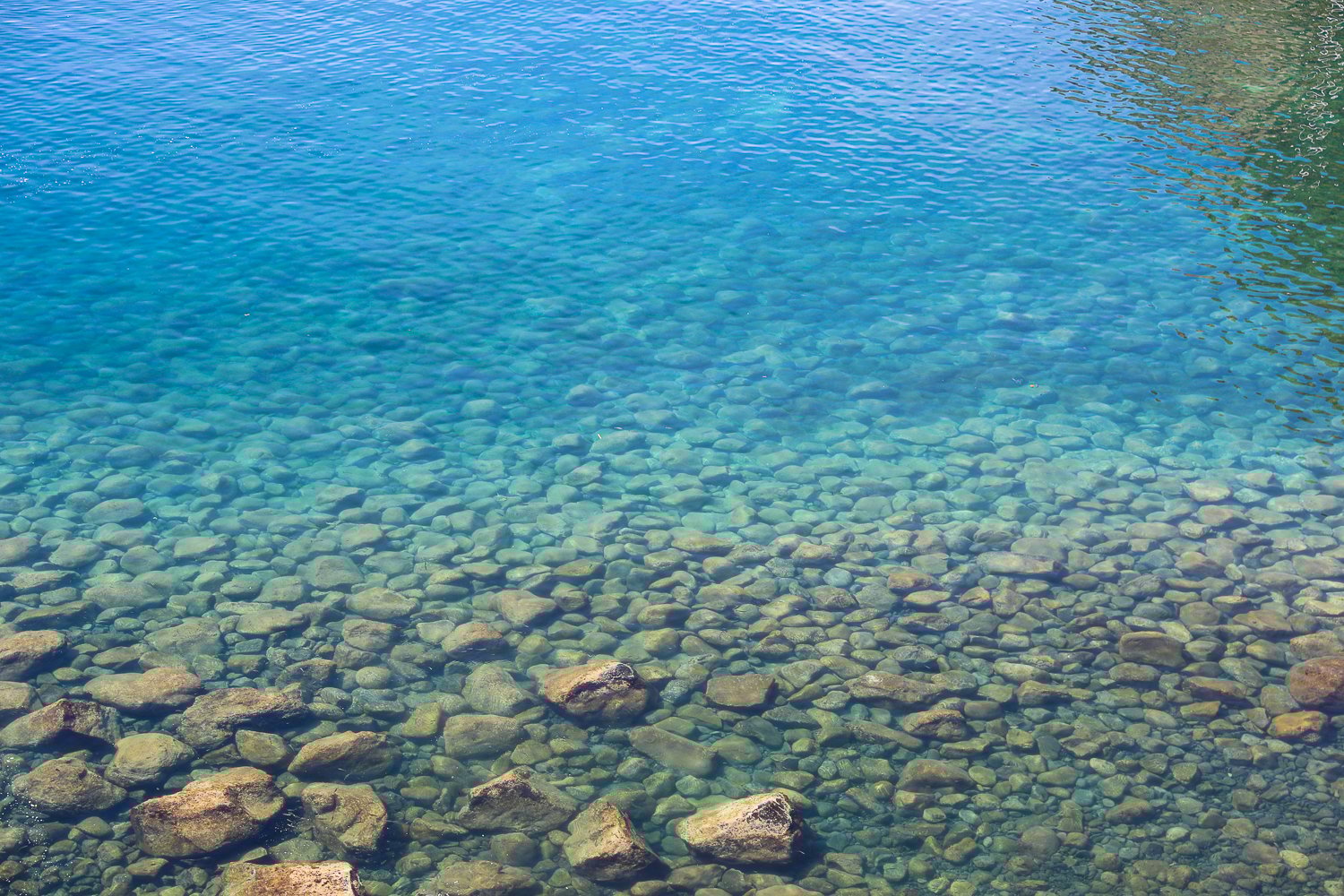 Rocks beneath the blue waters of Baia di Sorgeto