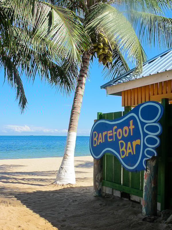 Foot-shaped signage that reads "Barefoot Bar" in Placencia. In this guide, you'll find the best places to visit in Belize and other top travel tips.
