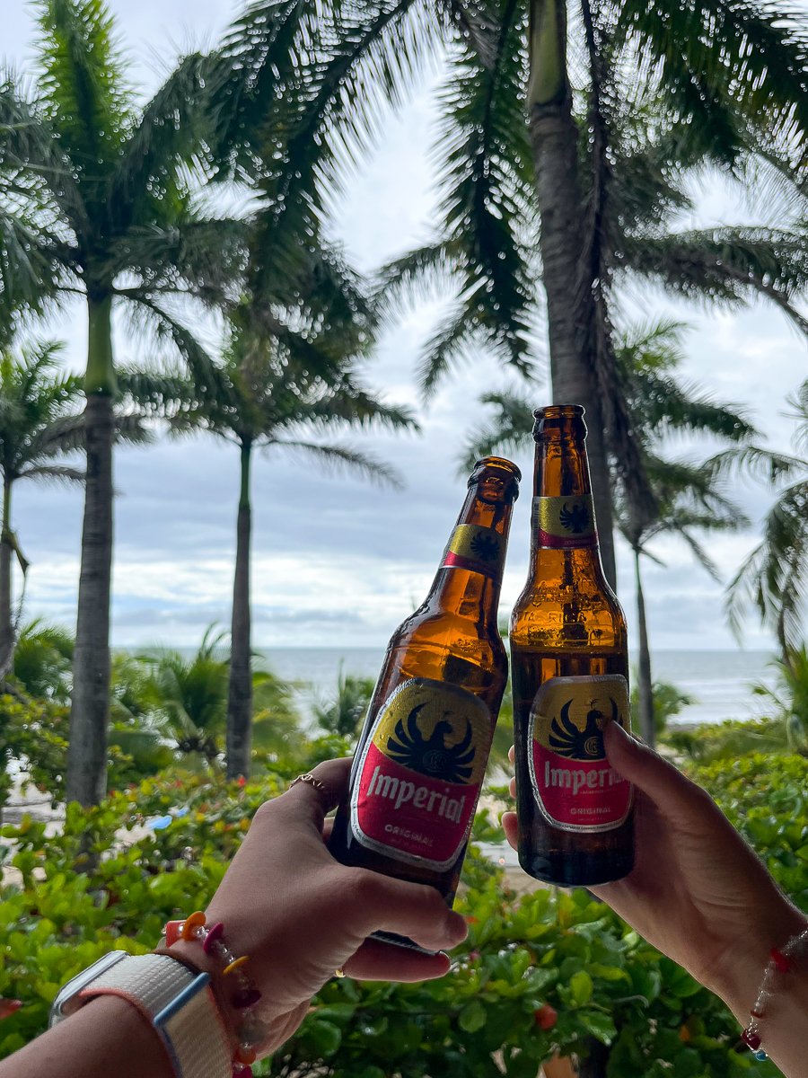 Two bottles of Imperial beer against a beautiful beach view in Playa Avellanas