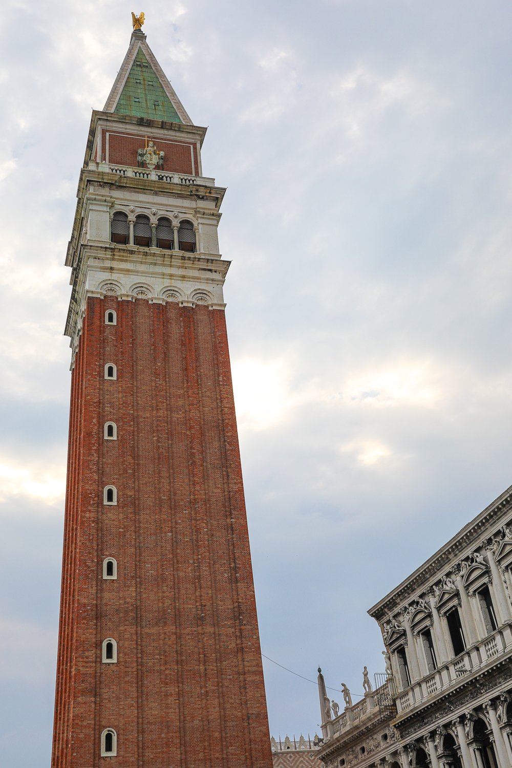 Looking up at St. Mark's Bell Tower and a cloudy sky from below