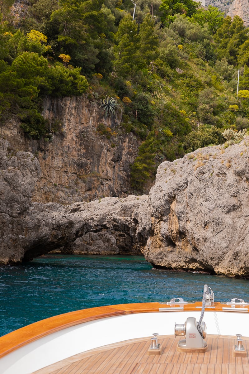 Cruising through the azure waters of Amalfi Coast while riding a boat. Going on boat tours is one of the top things to do in Amalfi Coast.