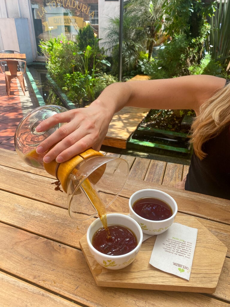 Pouring Colombian coffee in two cups at Cafe Cultor