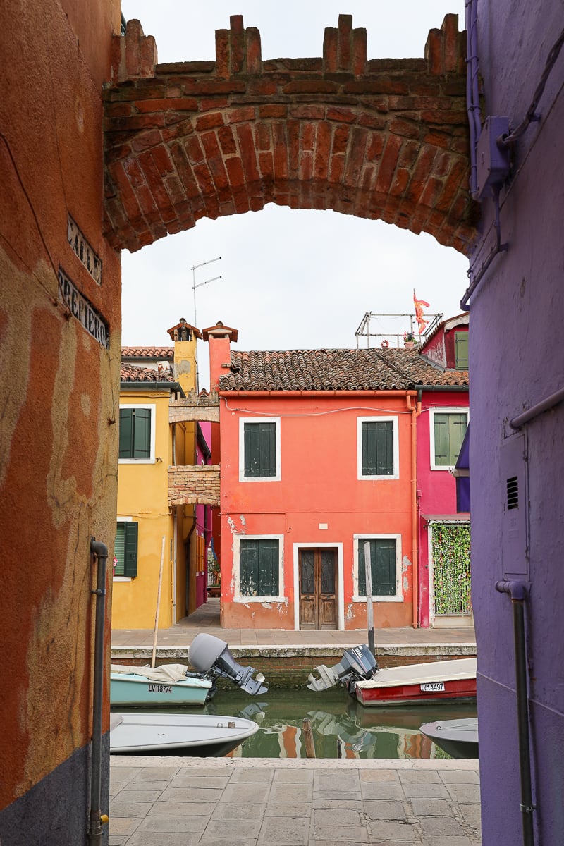 Bricked archway looking out Burano's colorful neighborhood. A simple sightseeing tour is one of the best things to do in Murano and Burano.