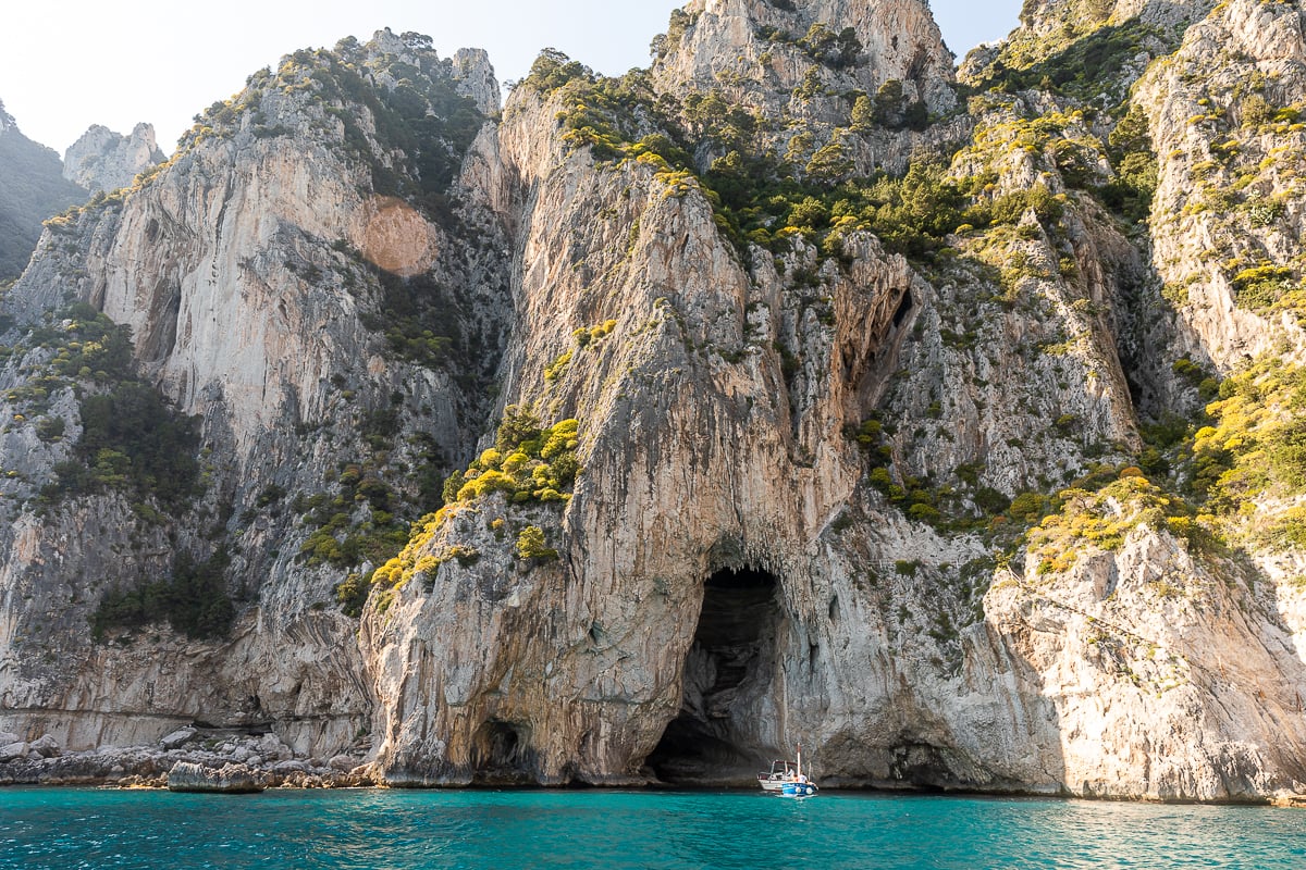 Boat exploring a cave inside the mountains. Going on boat tours is one of the unforgettable things to do in Amalfi Coast.