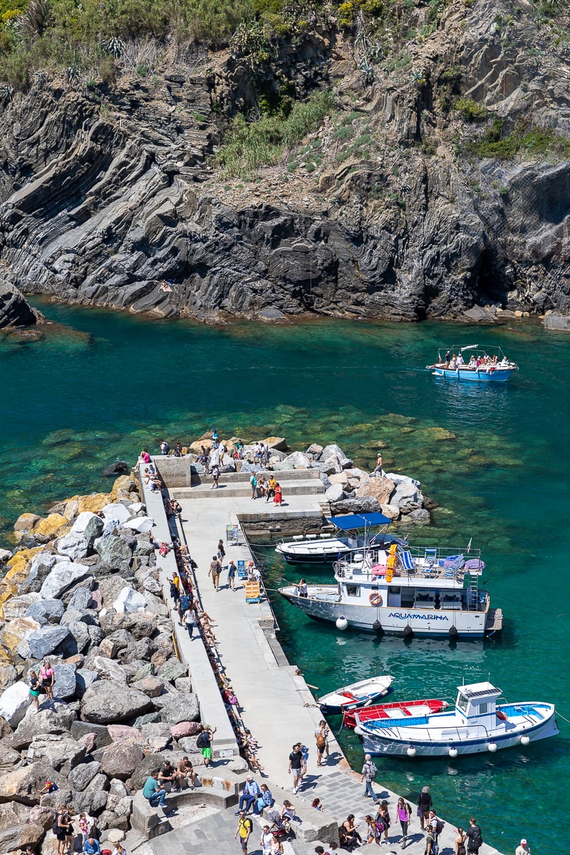 Blue sea water, boats, and a busy pier in Cinque Terre