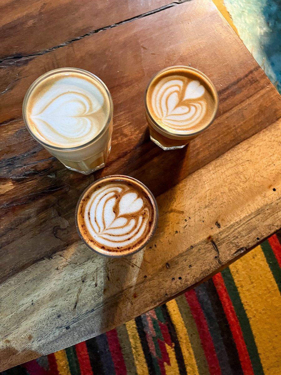 Three glasses of latte coffee on a wooden table in a Costa Rica café