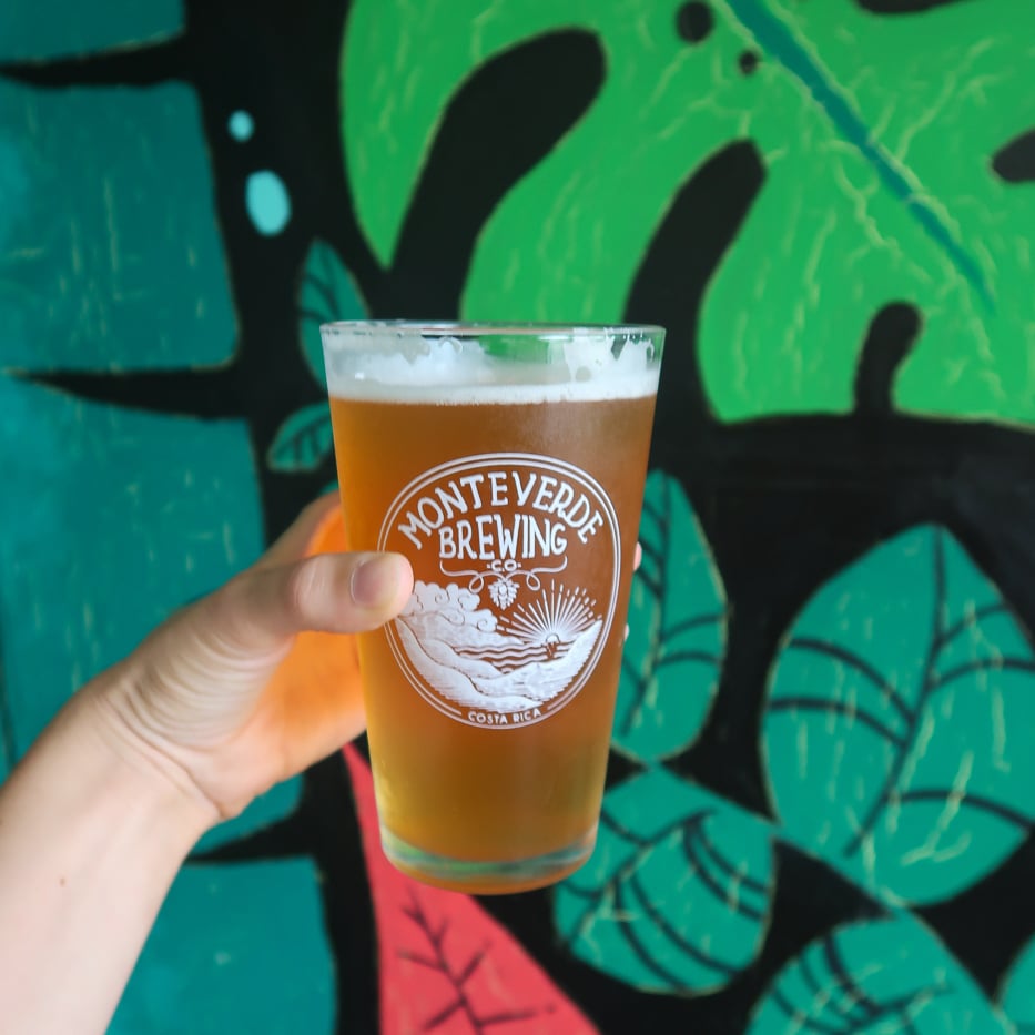 Holding a cold glass of beer from Monteverde Brewing Company. Visiting local breweries is one of the things to do in Monteverde, Costa Rica.