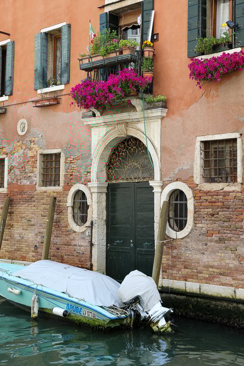 A canal-side home's front door with a boat docked in front of it