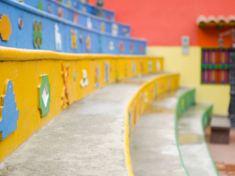 Colorful, decorated steps at Plazoleta de Los Zócalos. People-watching at the Zocalos Square is one of the things to do in Guatape, Colombia.