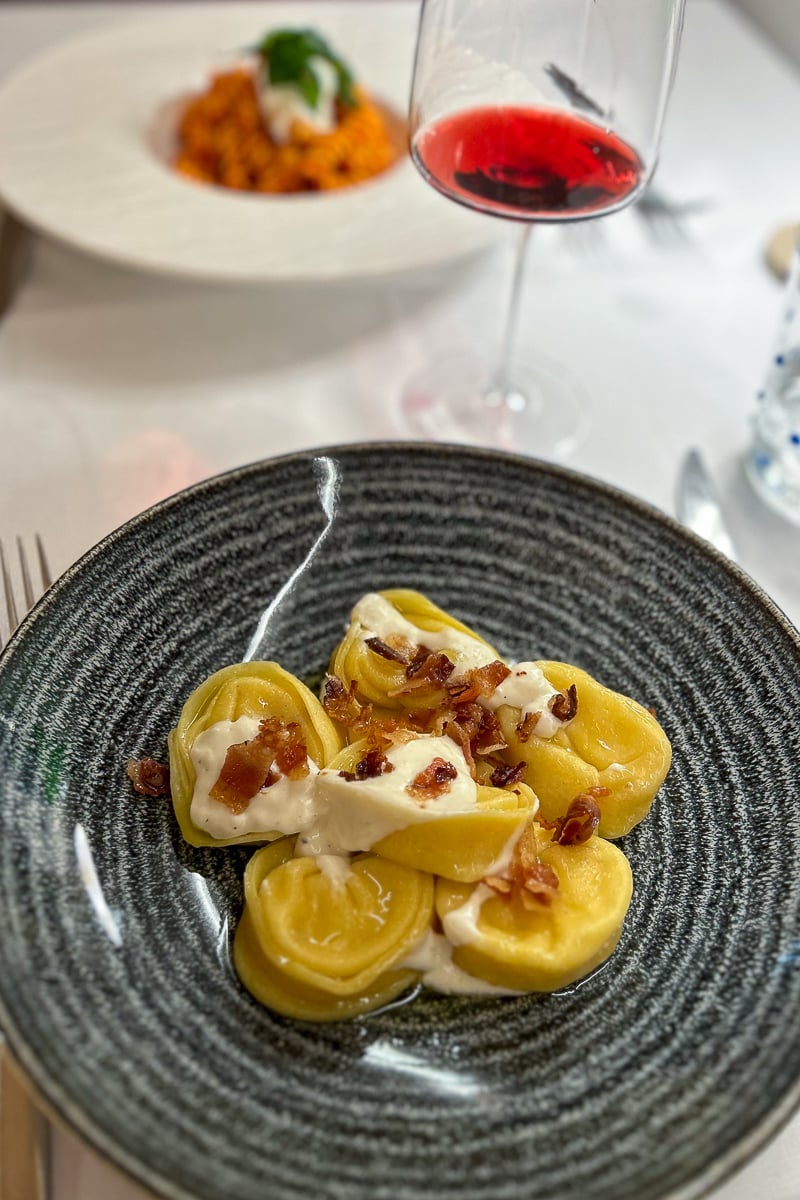 Delicious serving of carbonara tortelloni with parmigiano sauce and crispy guanciale at Il Molino restaurant