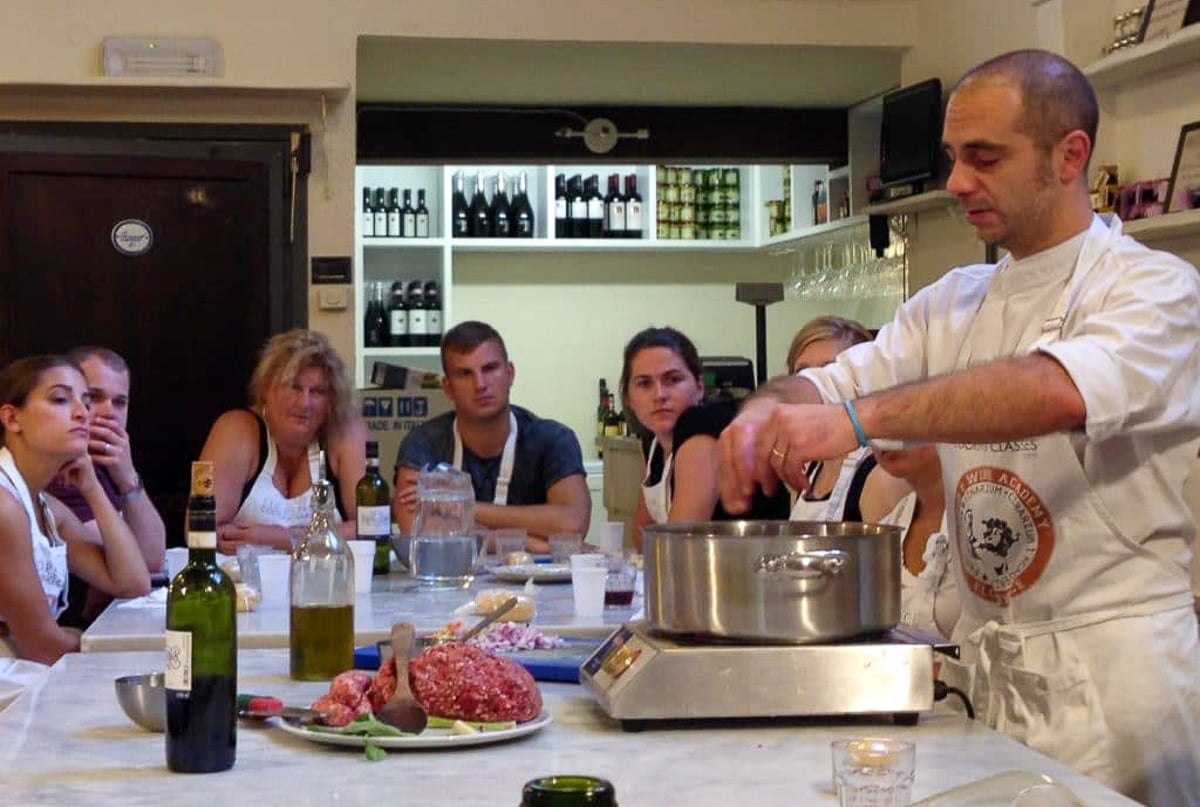 A chef demonstrating how to make Tuscan-style bolognese in a cooking class