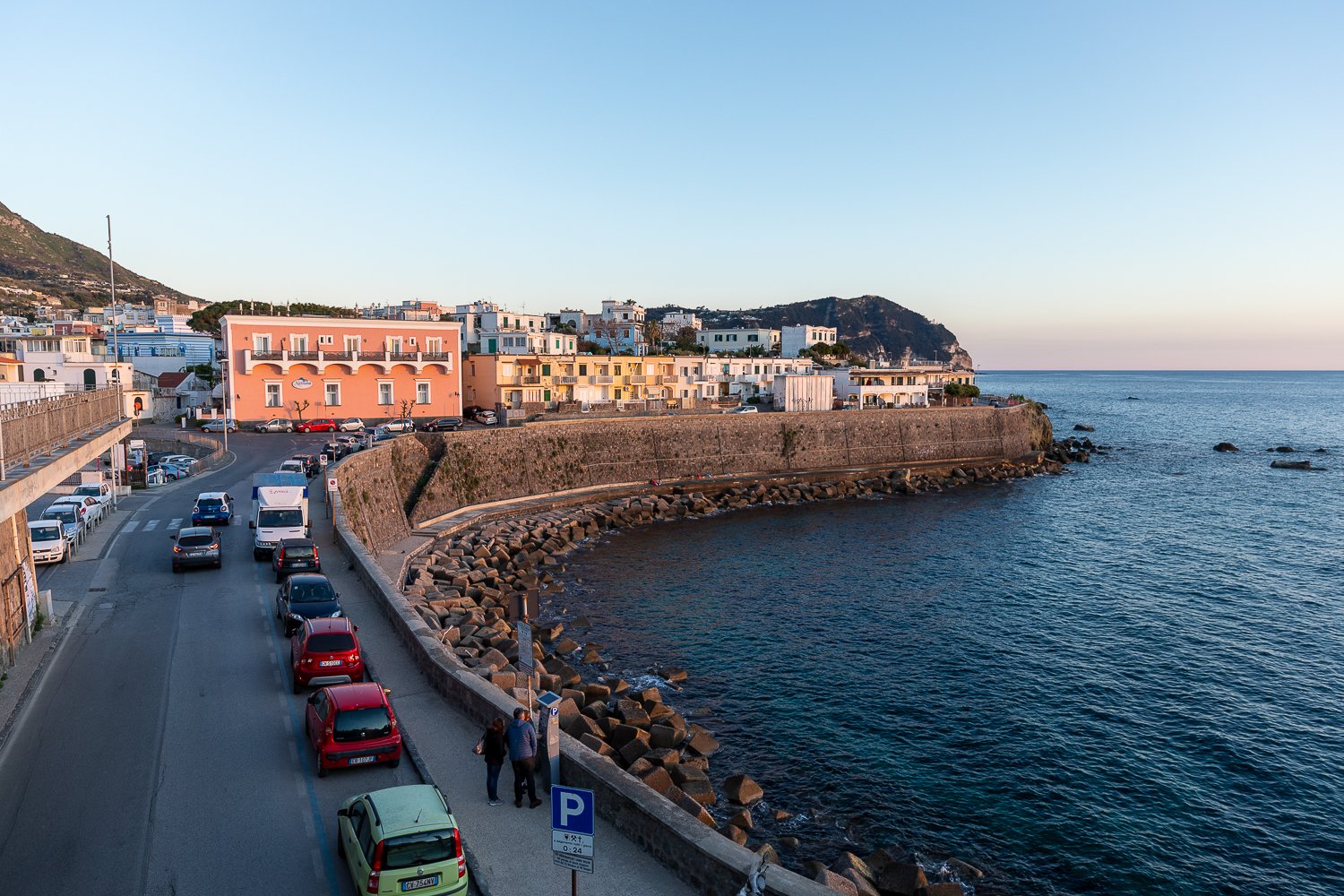 Cars lined up on the beachside road of Forio, a village in Campania, Italy