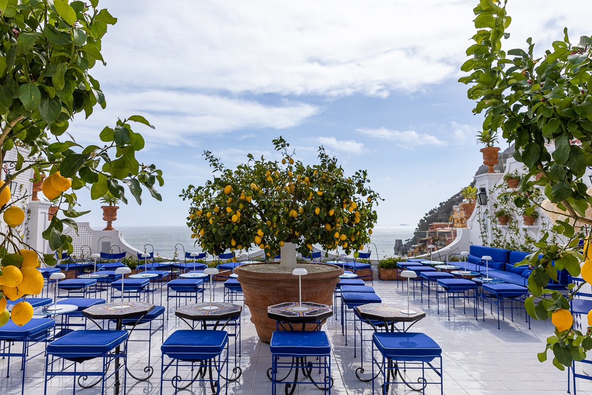 Colorful seatings and lemon trees at Franco's Bar with an enchanting view of the vast ocean