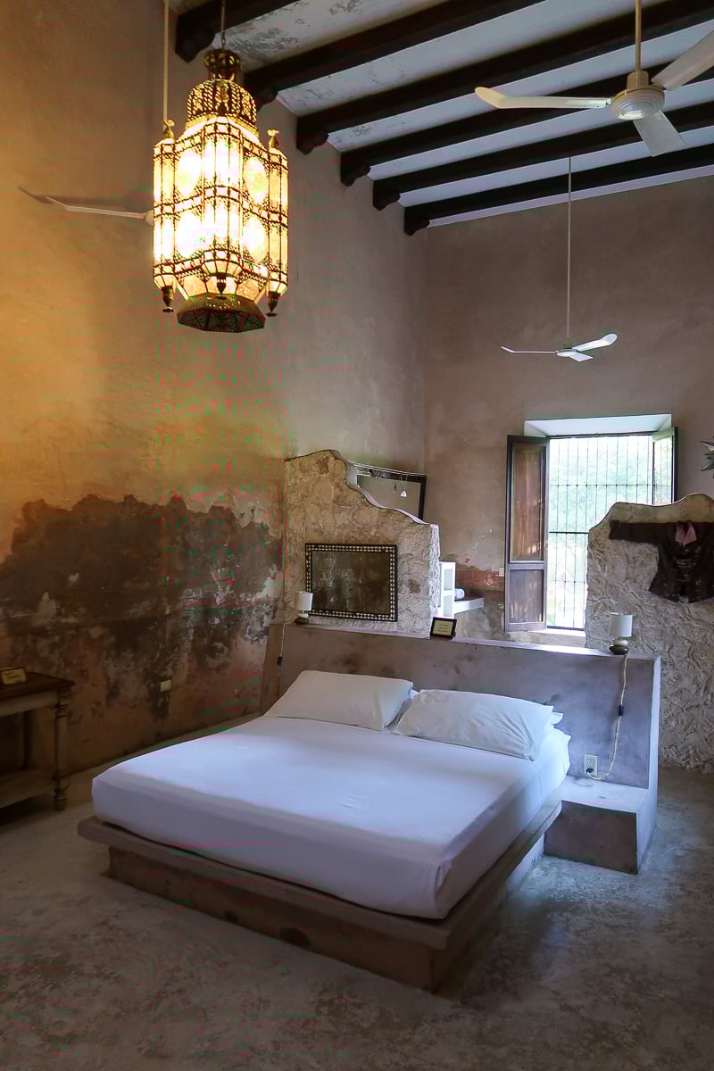 Simple, white bed at Hacienda Sacnicte. Staying at century-old haciendas is one of the best things to do in Izamal.
