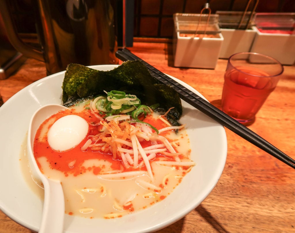 A bowl of ramen with black chopsticks in a Japanese restaurant. Eating ramen is a must-try during your two days in Kyoto.