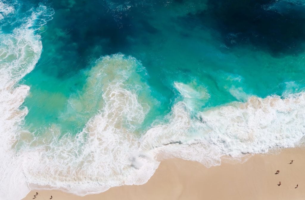 Aerial view of beautiful turquoise waters by a sandy beach