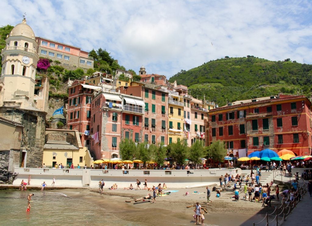 People on a small beach in Vernazza on a sunny day.