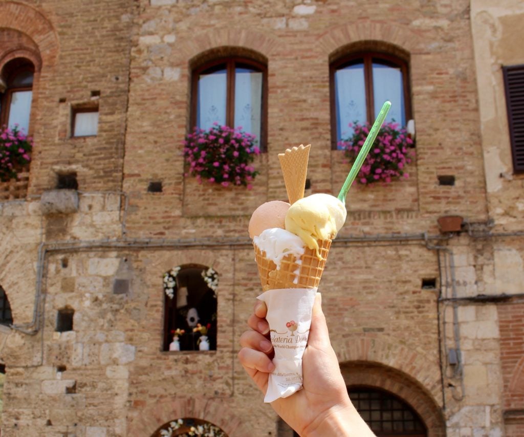 Holding up a cone of ice cream while touring Tuscany in one day