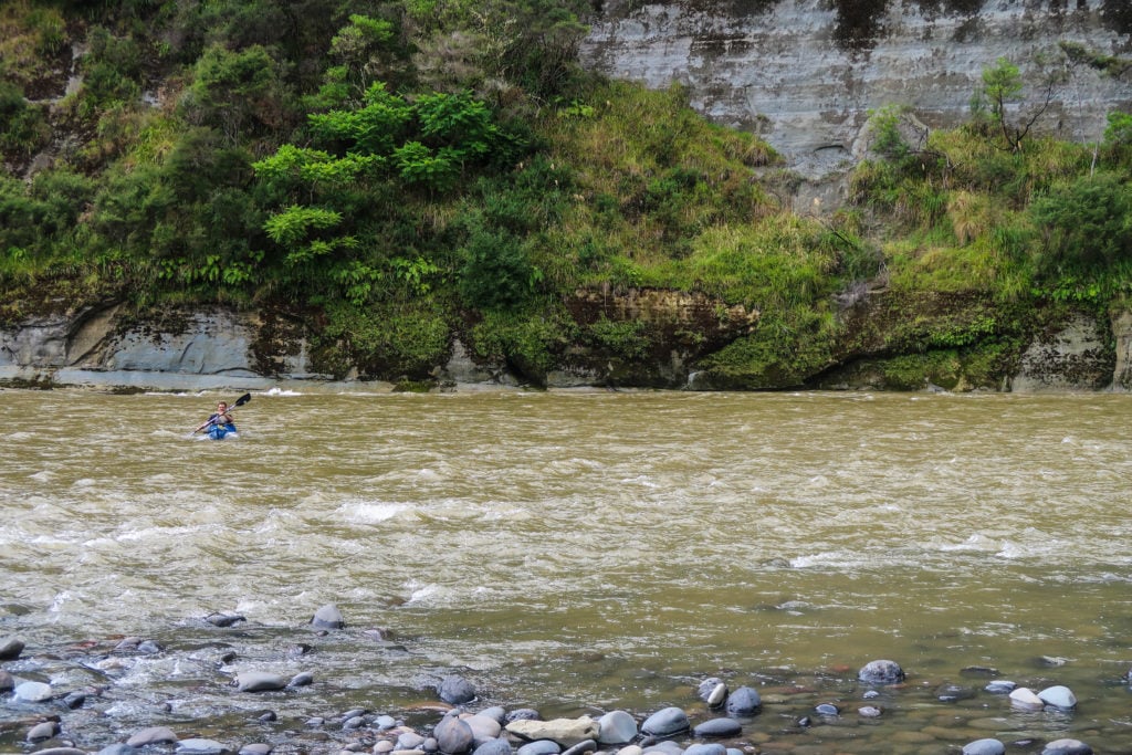 Rowing a canoe on rapid waters. The Whanganui River Journey itinerary will not be complete without trying the rapids.