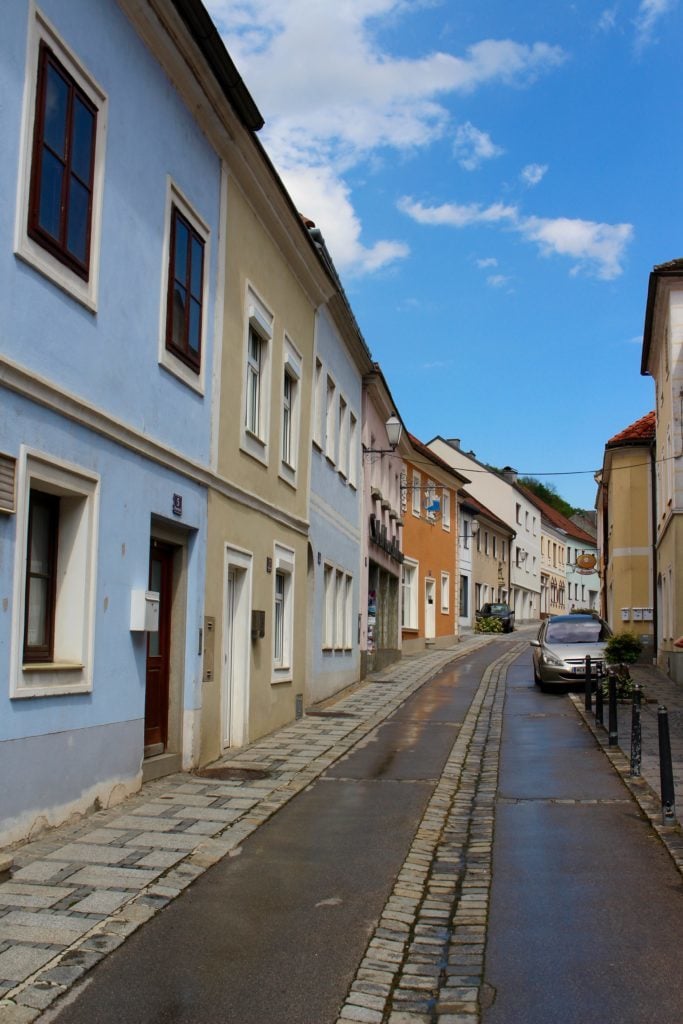 A quiet street in Melk, Austria lined with colorful buildings. Explore the beauty of Europe by booking your Viking River Cruises Grand European Tour.