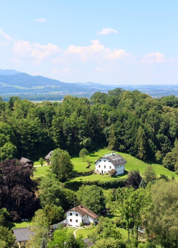 Aerial view of lush mountain trees and cozy farmhouses in Salzburg, Austria - one of the destinations of our Viking River Cruises Grand European Tour