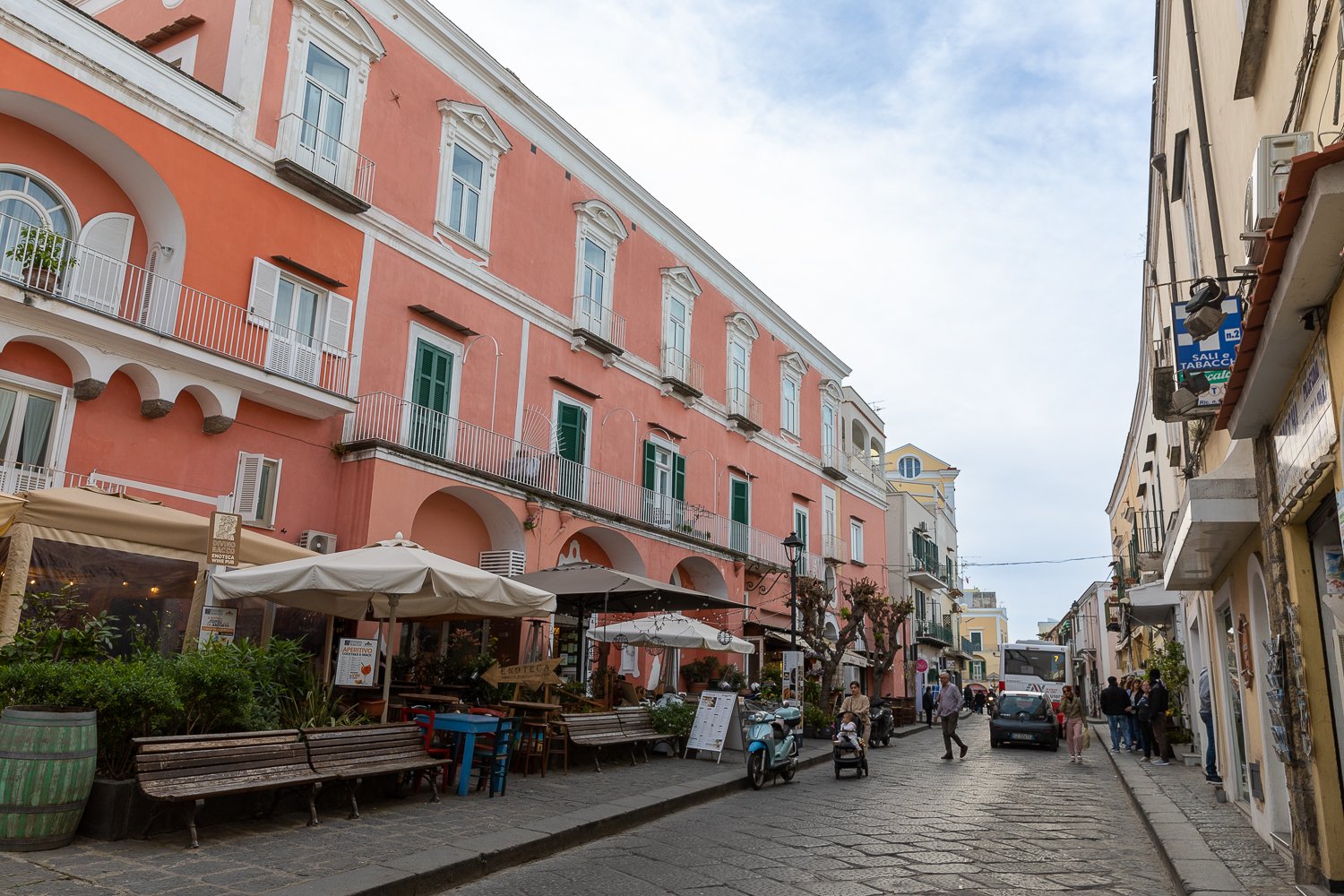 Locals and tourists visiting Ischia Ponte and walking between its colorful buildings