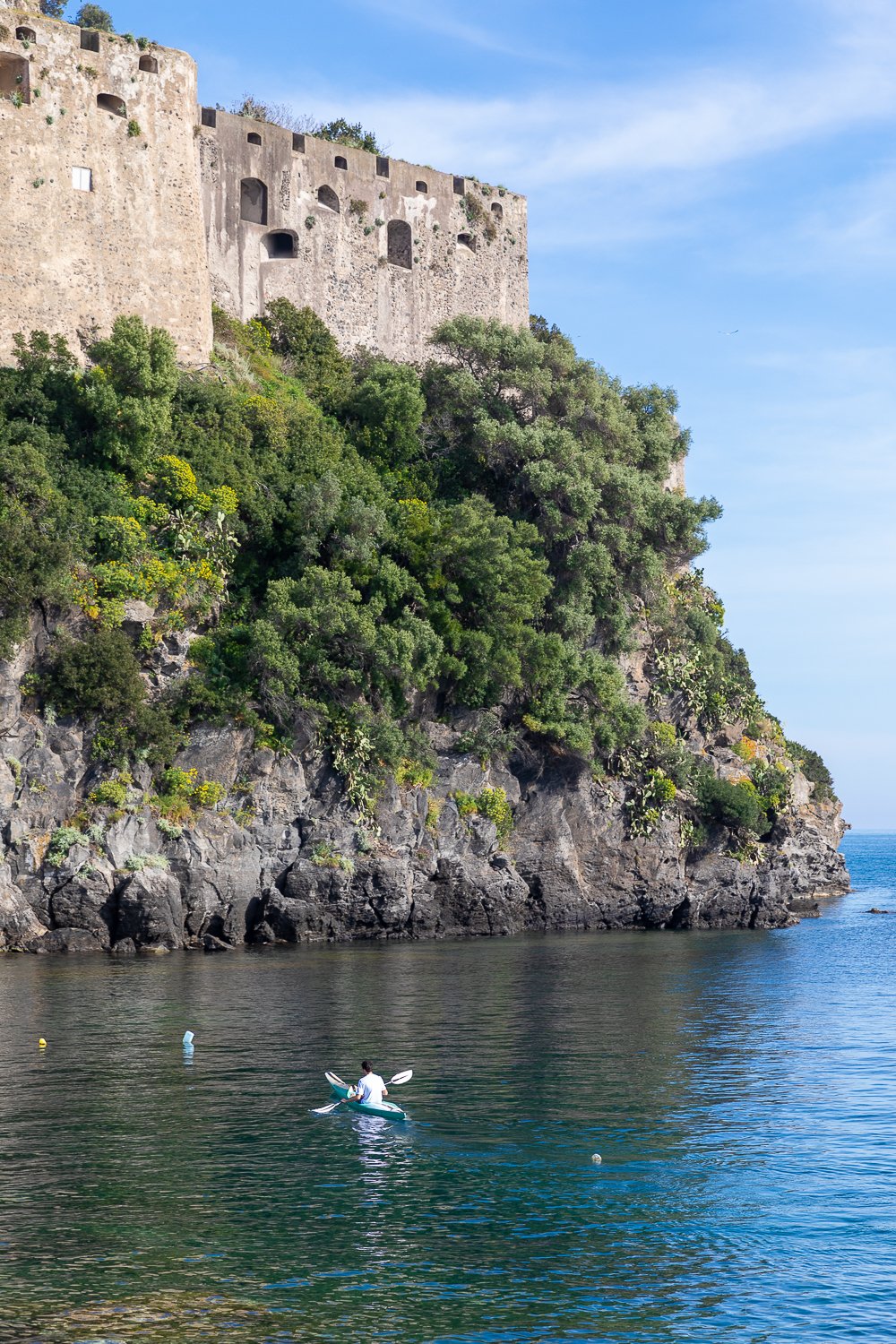 Man kayaking around Isola d'Ischia. Going on a kayak tour with a local guide is one of the best things to do in Ischia, Italy.