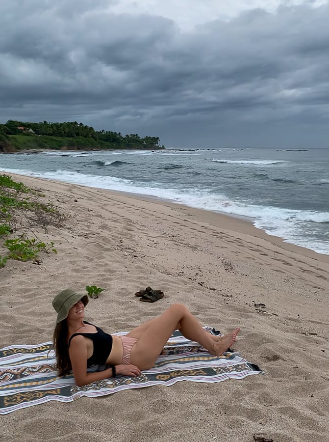 Maddy relaxing on a beach towel in Playa Blanca, Costa Rica