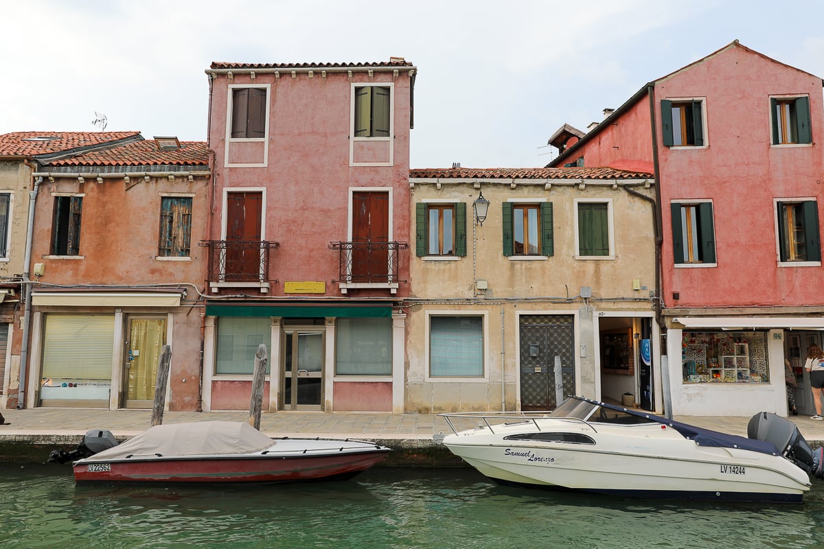 Speedboats docked on a canal in an older neighborhood in Murano, Venice. A perfect day trip to Murano and Burano will not be complete without a boat ride.