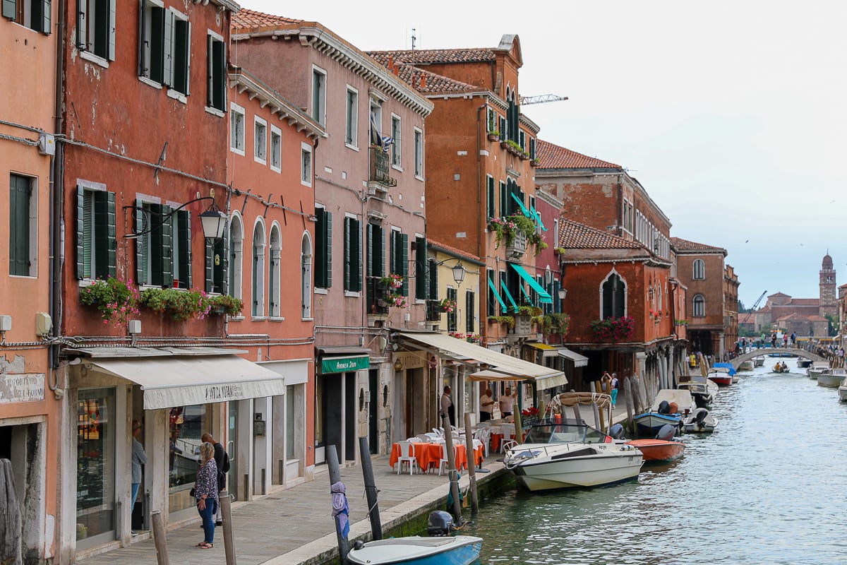 Quaint, colorful shops by a canal in Murano, Venice