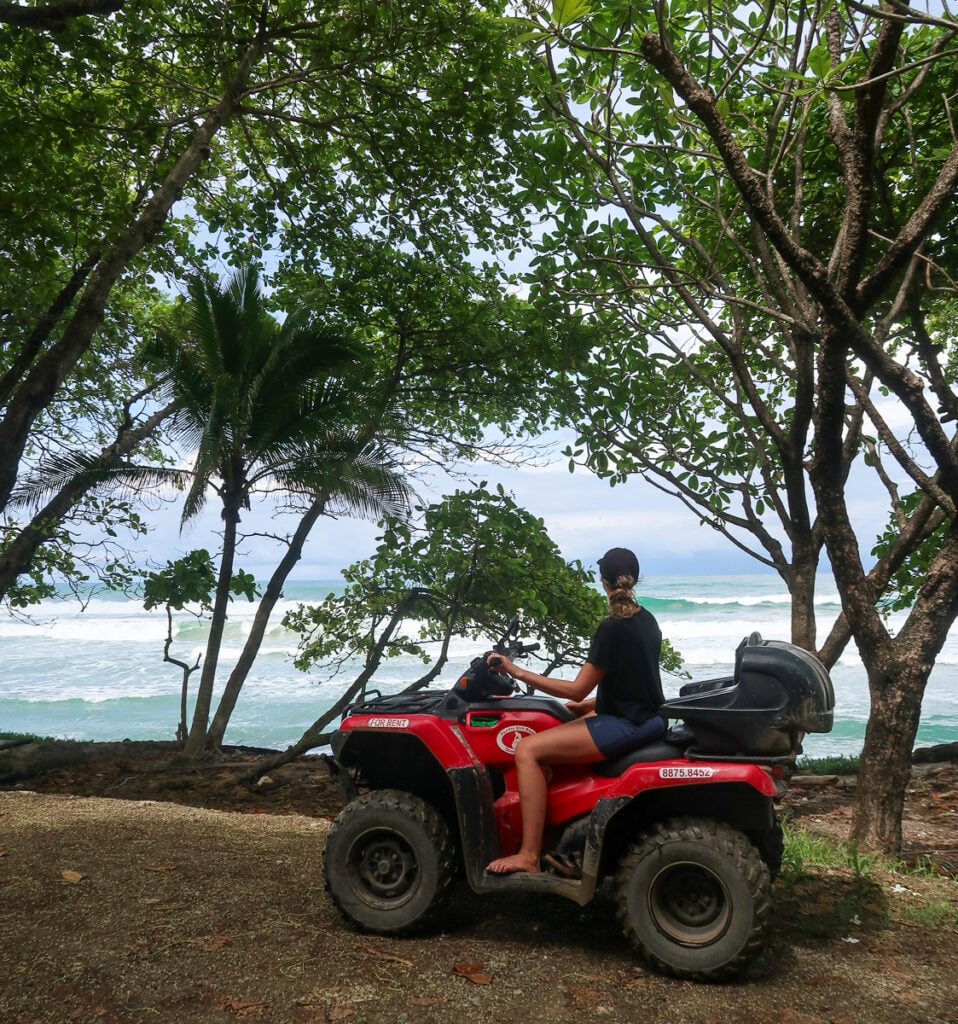 Maddy riding an ATV while enjoying the view of a beach in Nosara