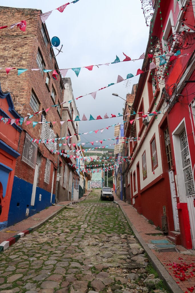 Mossy, cobbled street lined with colorful buildings in the old town of Bogota