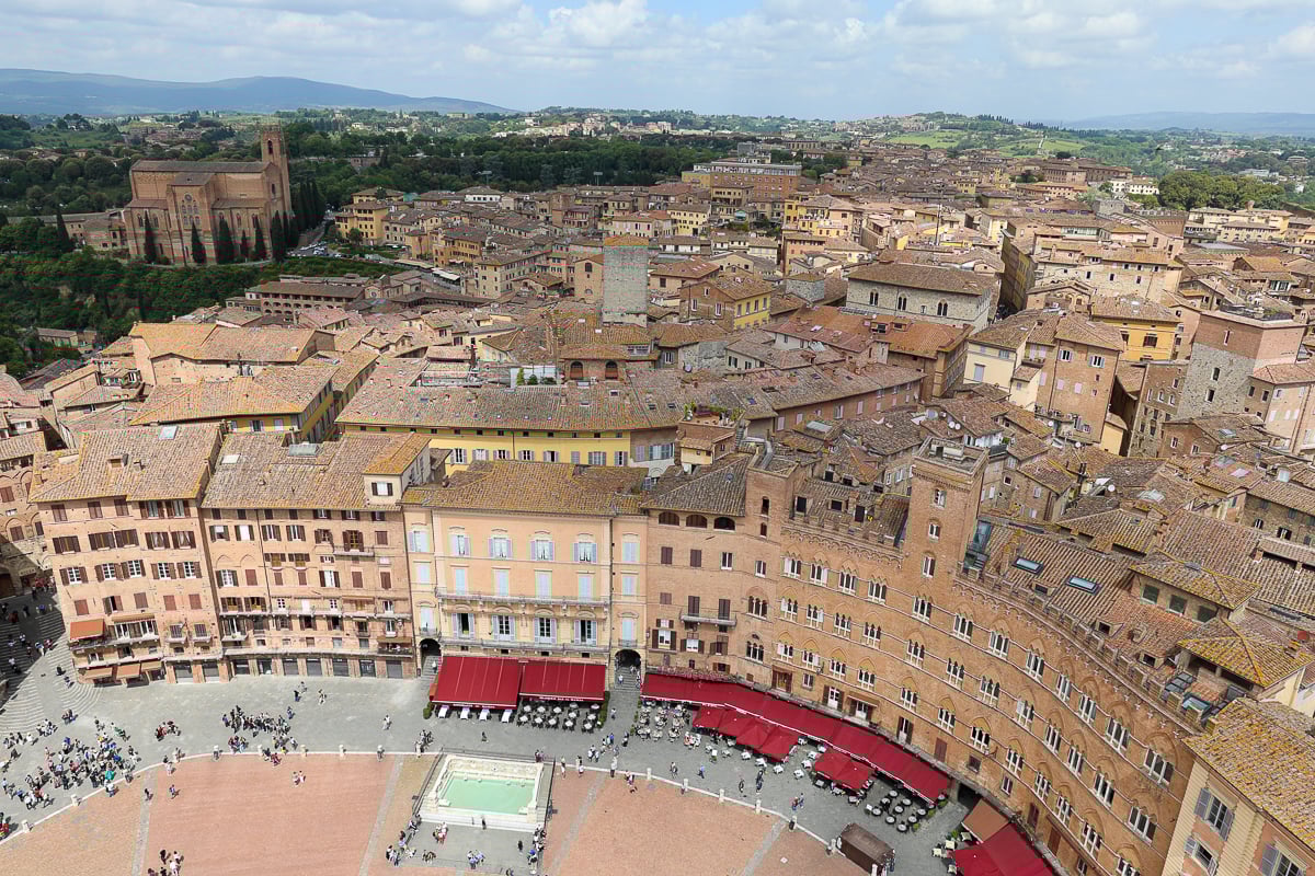 Busy crowds of people roaming around Piazza del Campo in Siena. This great medieval square is a place to add in your Tuscany In One Day itinerary.