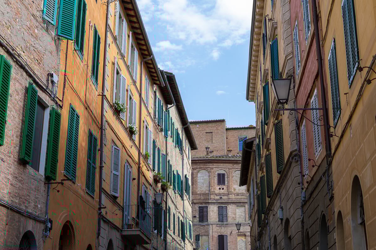 Colorful houses in a narrow street in Siena, Italy