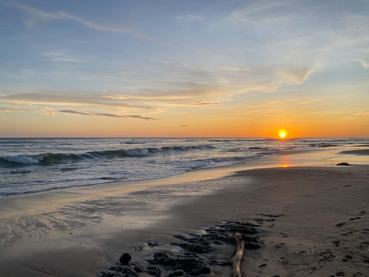 Orange sun slowly setting as seen from Playa Negra, Costa Rica