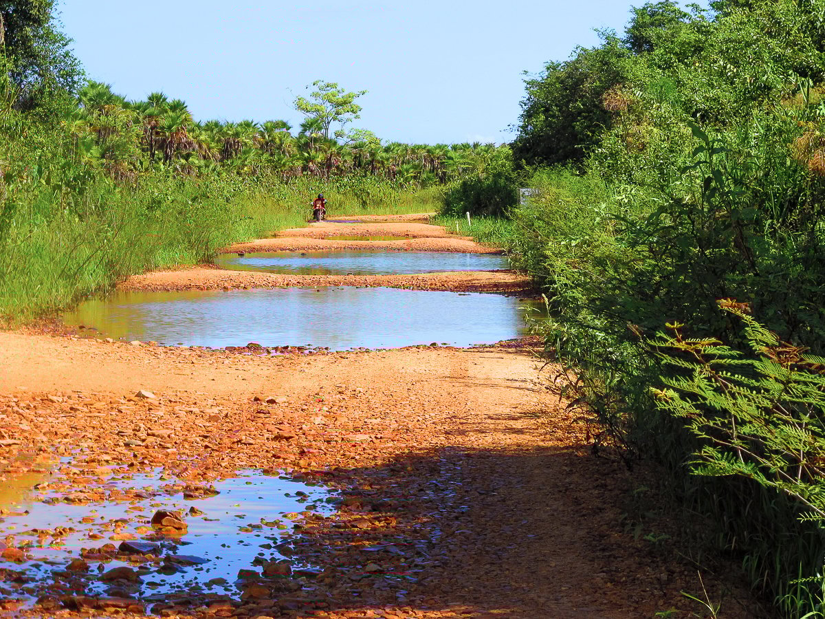 Potholes on a road in Belize. Make sure to familiarize yourself with roads and transportation in Belize before you visit.