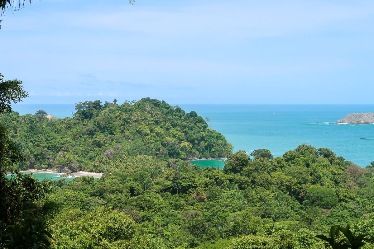 Lush jungle trees and a picturesque beach of Punta Catedral. Hiking along this trail is one of the best things to do in Manuel Antonio.