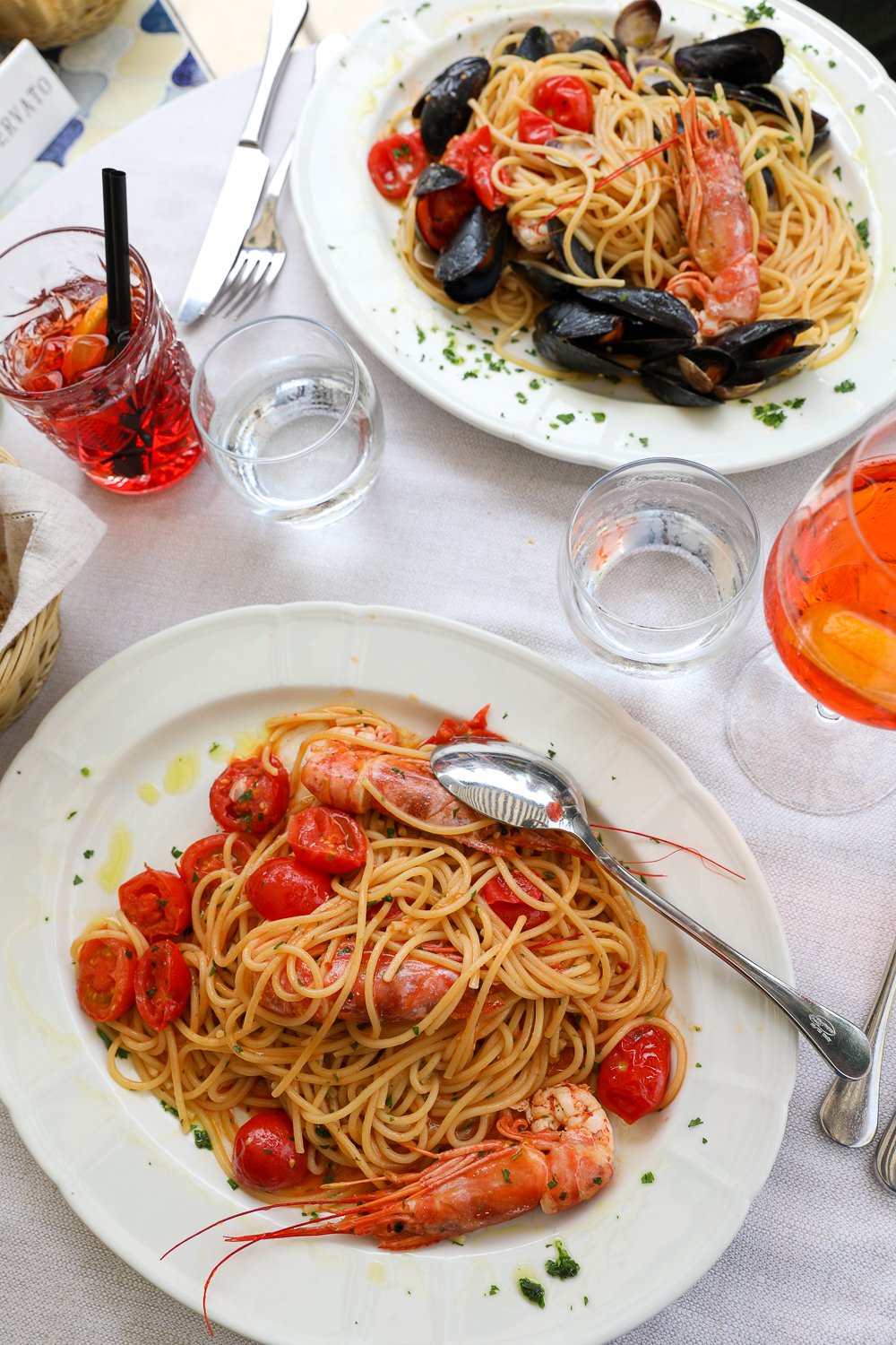 Delicious spaghetti di scampi alla busara and spaghetti allo scoglio with an Aperol sprotz and a negroni. Eating amazing seafood in Venice is one of the best things to do in 2 days in Venice.