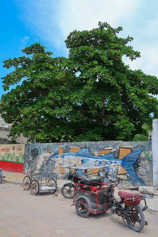 Motorcycles parked near the colorful street murals in Sisal