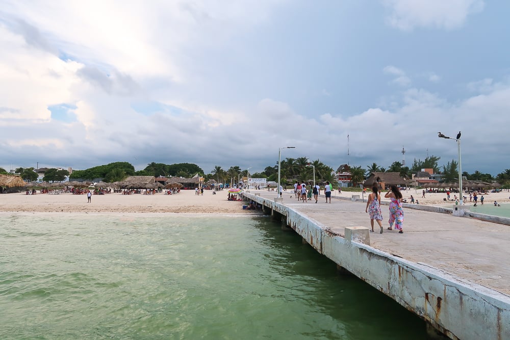 People walking along a walkway by the beach in Sisal