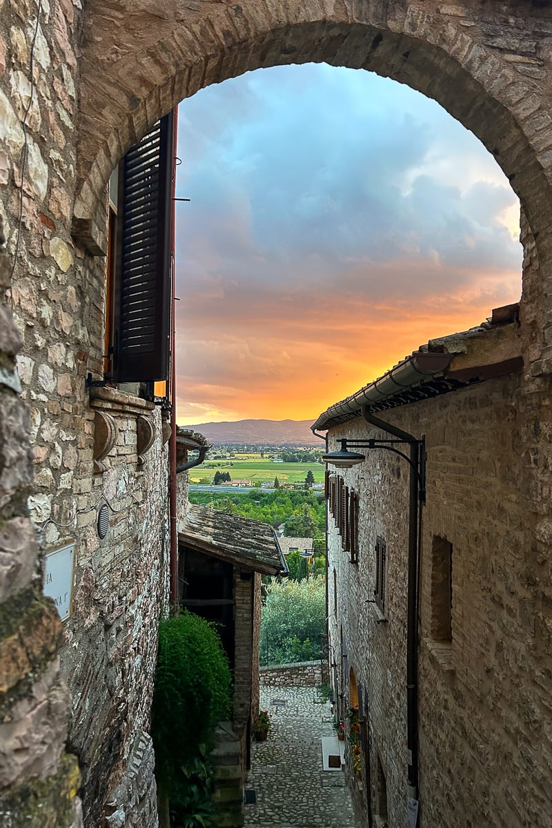 Beautiful orange sunset as seen from an arched alleyway in Spello