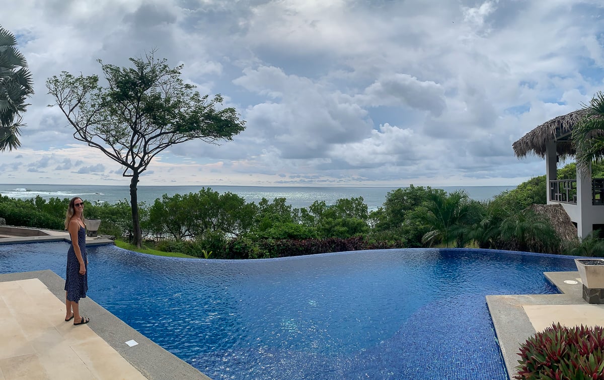 Maddy by the pool of a vacation rental with a vast view of the beach. In this guide, you'll find all you need to know before you go to Playa Avellanas.