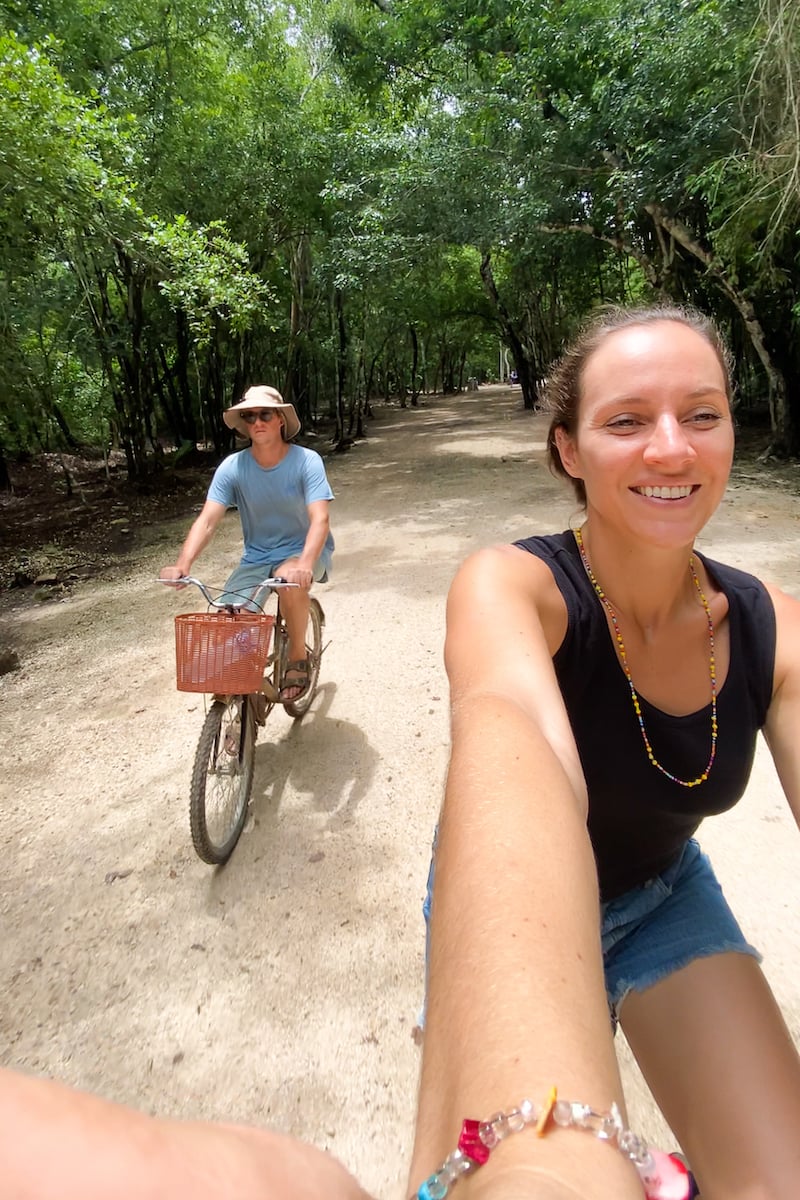Maddy and Cacey biking along a dirt road in the jungle to see the ruins of Coba