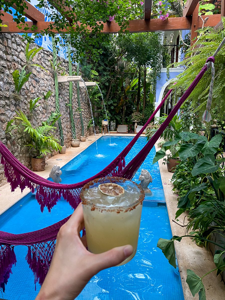 Holding a drink with the view of the pool at Le Muuch Boutique Hotel in Valladolid
