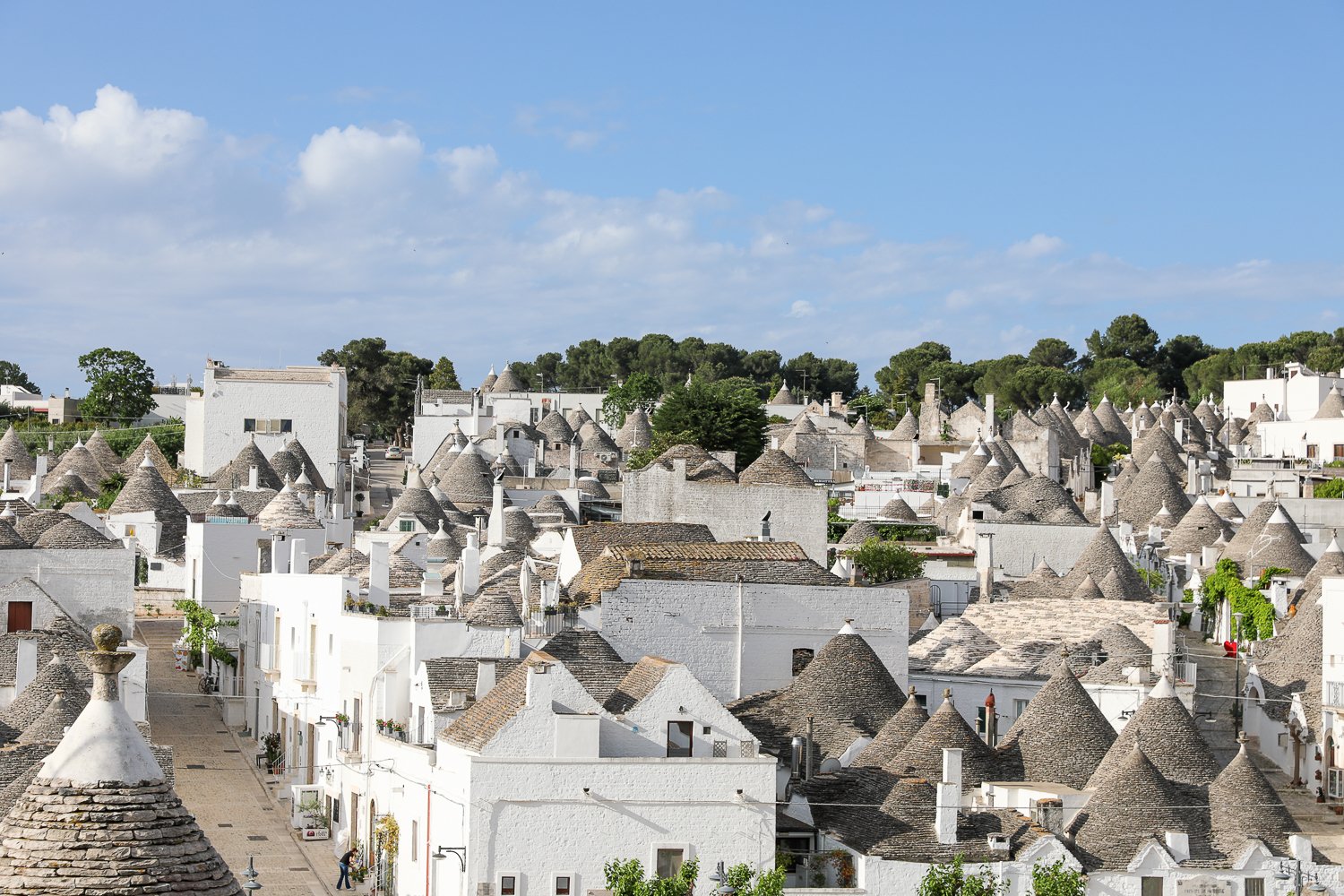 Beautiful view of trulli huts as seen from a terrace. If you're wondering what to do in Alberobello, go up the Villa Comunale Belvedere and admire the panoramic view of trulli.